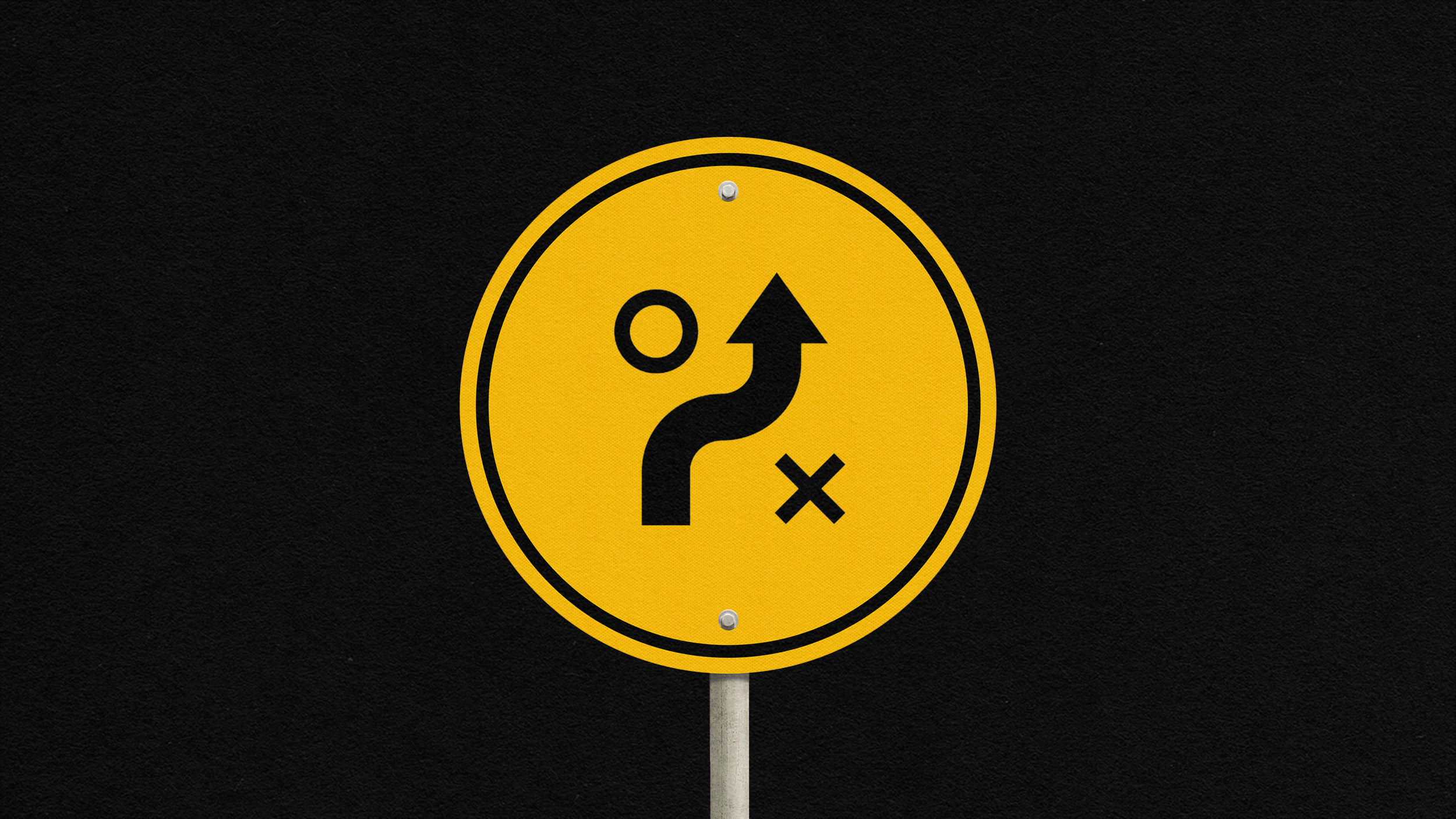 Yellow round sign with black symbols: arrow curving up, circle on left, X on right, on a black background.