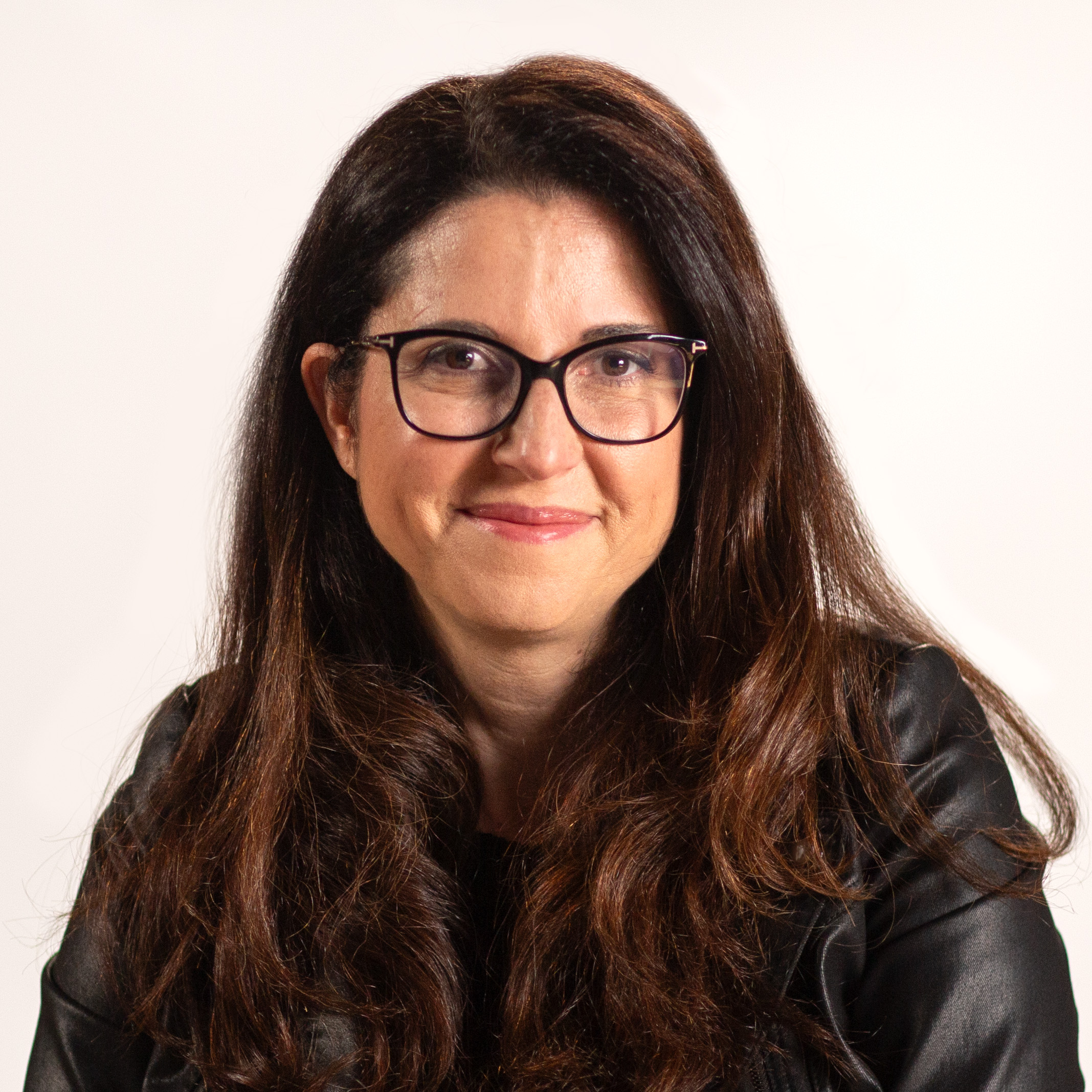 A woman wearing glasses and a leather jacket.